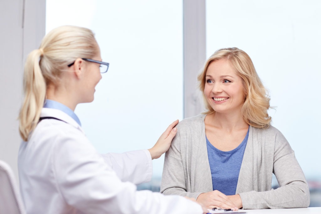 doctor talking to woman patient at hospital